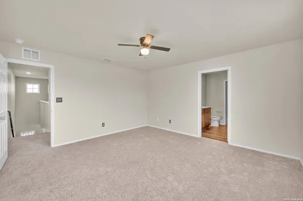 an empty room with closet and a ceiling fan