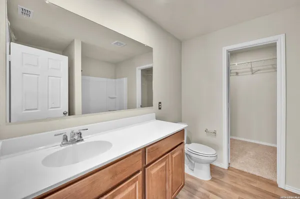 a bathroom with a granite countertop sink a toilet and a large mirror