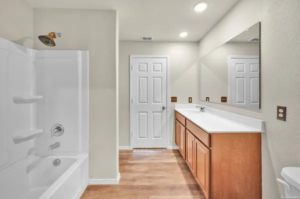 a bathroom with a granite countertop sink a mirror and a bathtub