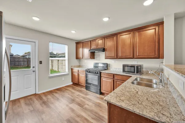 a kitchen with stainless steel appliances granite countertop a sink stove and refrigerator