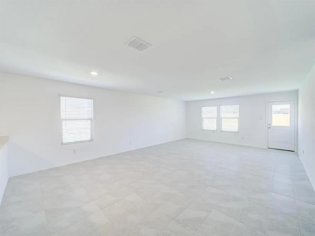 352 Sun Bluff Road Fort Worth, TX 76052 - Photo 14 of 33 Spacious room featuring light-toned tile flooring, recessed lighting, and multiple windows with blinds