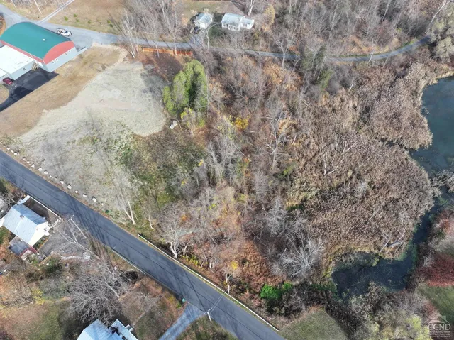 a view of a dry yard with wooden fence