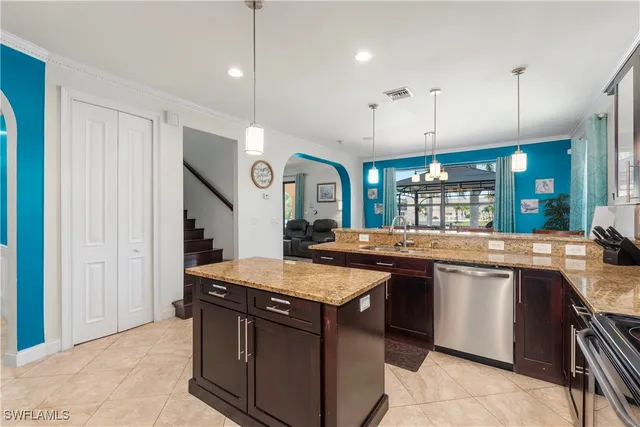 a kitchen with stainless steel appliances granite countertop a refrigerator a stove a sink a microwave and a refrigerator