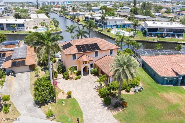 an aerial view of a house with a garden and lake view