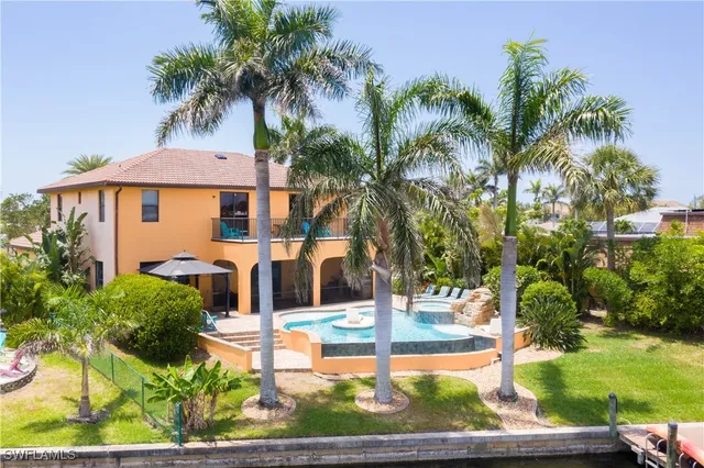 a swimming pool with outdoor seating and barbeque oven