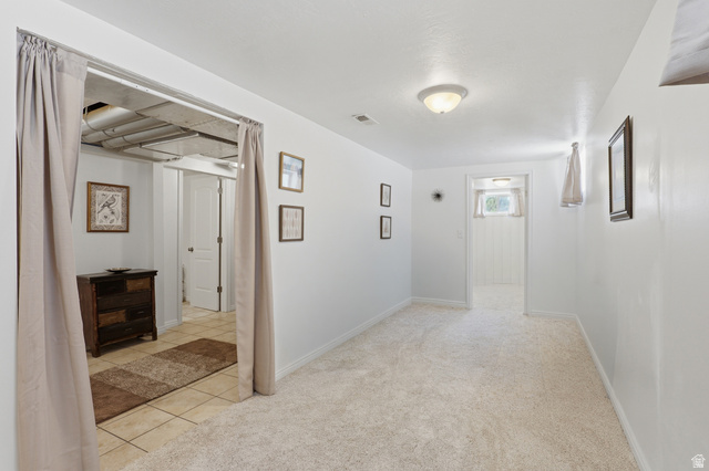 724 Canyon Road Ogden, UT 84404 - Photo 18 of 35 Carpeted room with white walls, a flush-mount ceiling light, and a doorway leading to a tiled area