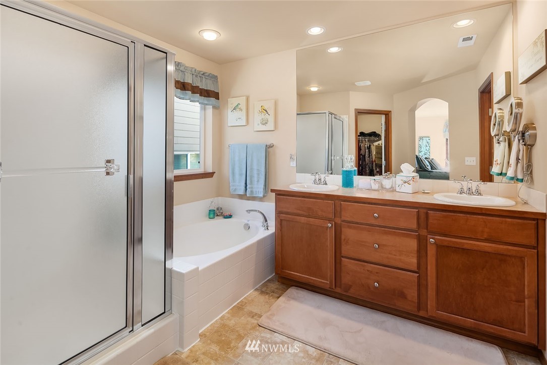 23019 42nd Drive Southeast Bothell, WA 98021 - Photo 11 of 19 a bathroom with a tub a double vanity sink and mirror