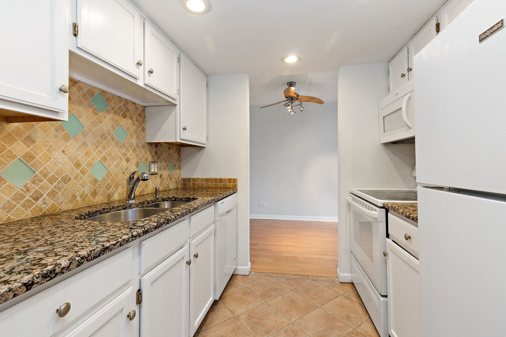 1 Renaissance Place, Unit 702 Palatine, IL 60067 - Photo 4 of 10 a kitchen with granite countertop white cabinets and white appliances