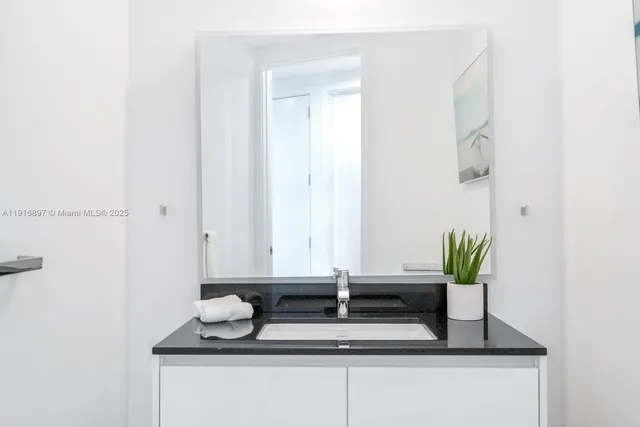 a bathroom with a granite countertop sink and a mirror