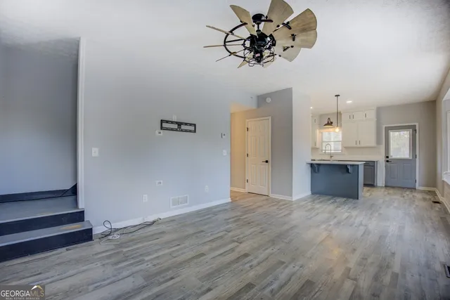 a view of a kitchen with wooden floor and a sink