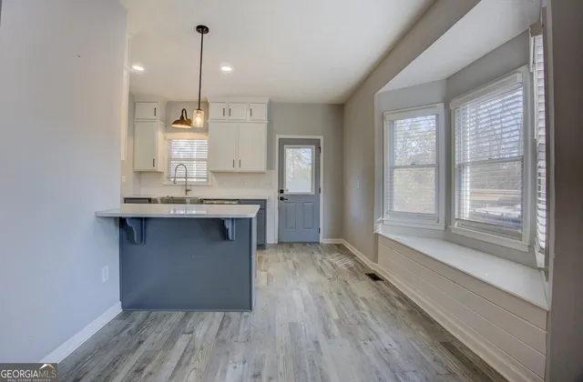 a kitchen with kitchen island a sink appliances wooden floor and a window