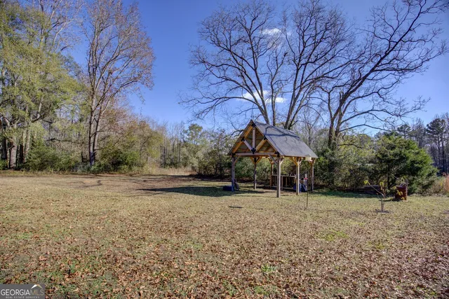 a view of a barn with large trees
