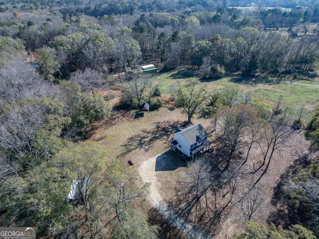 an aerial view of house with yard and trees