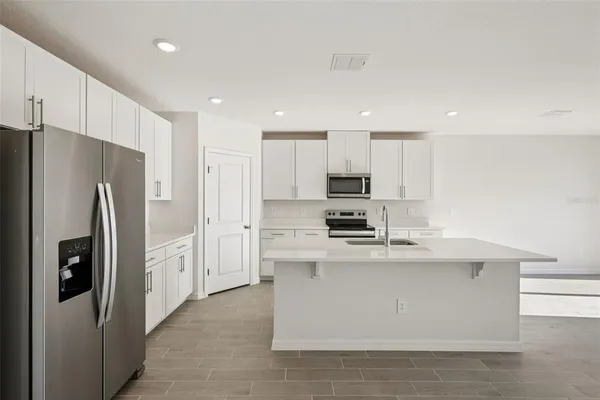 a kitchen with stainless steel appliances a refrigerator stove microwave and cabinets