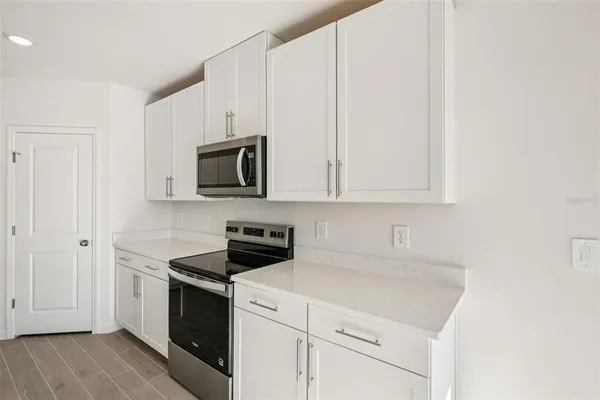 a kitchen with white cabinets and stainless steel appliances