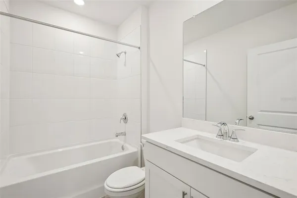 a bathroom with a granite countertop sink a toilet and shower