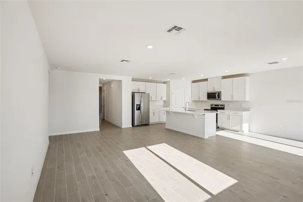 a view of a kitchen with refrigerator and white cabinets