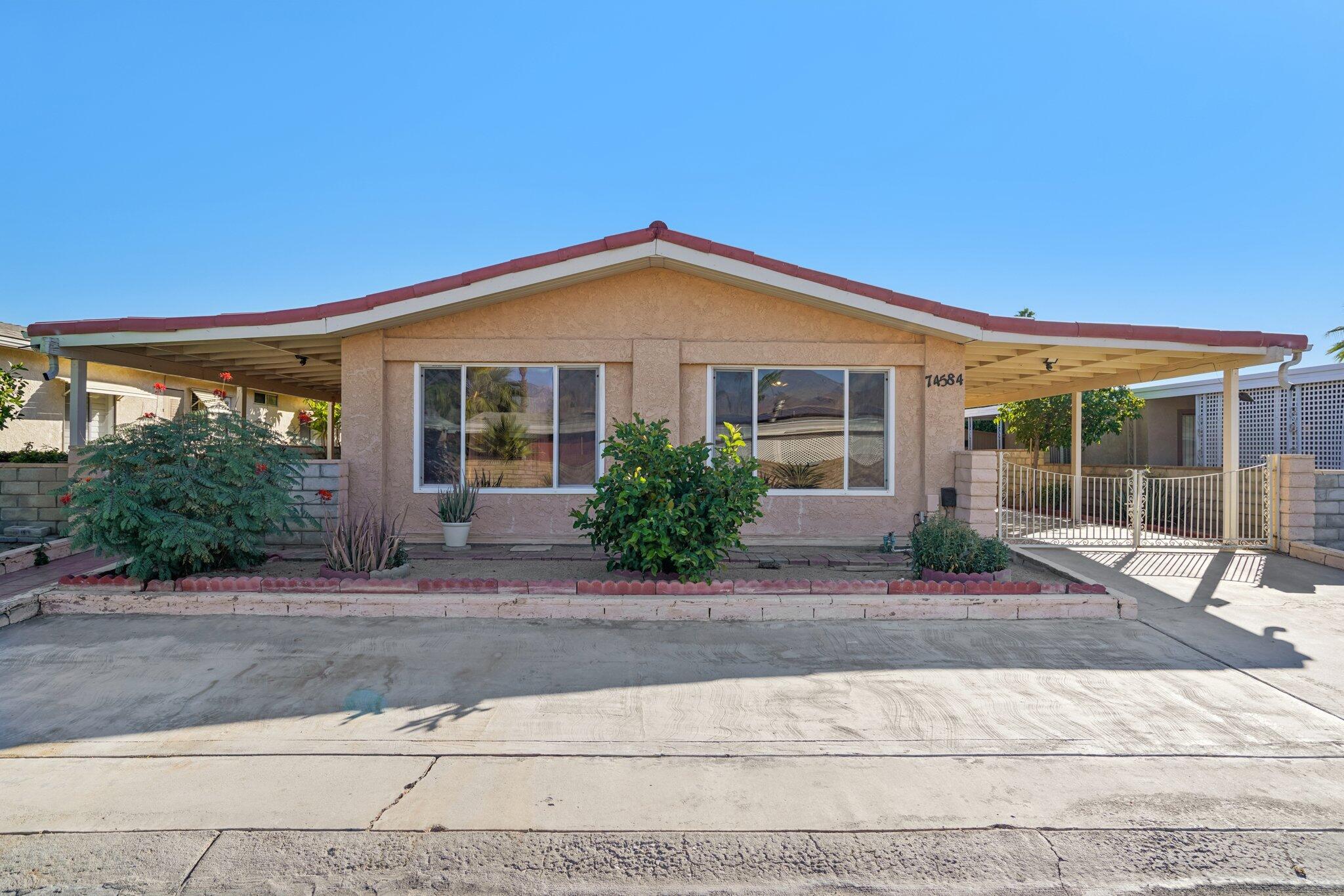 74584 Nevada Circle East Palm Desert, CA 92260 - Photo 1 of 46 a front view of a house with porch and glass windows