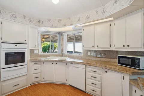 a kitchen with cabinets stainless steel appliances and a window