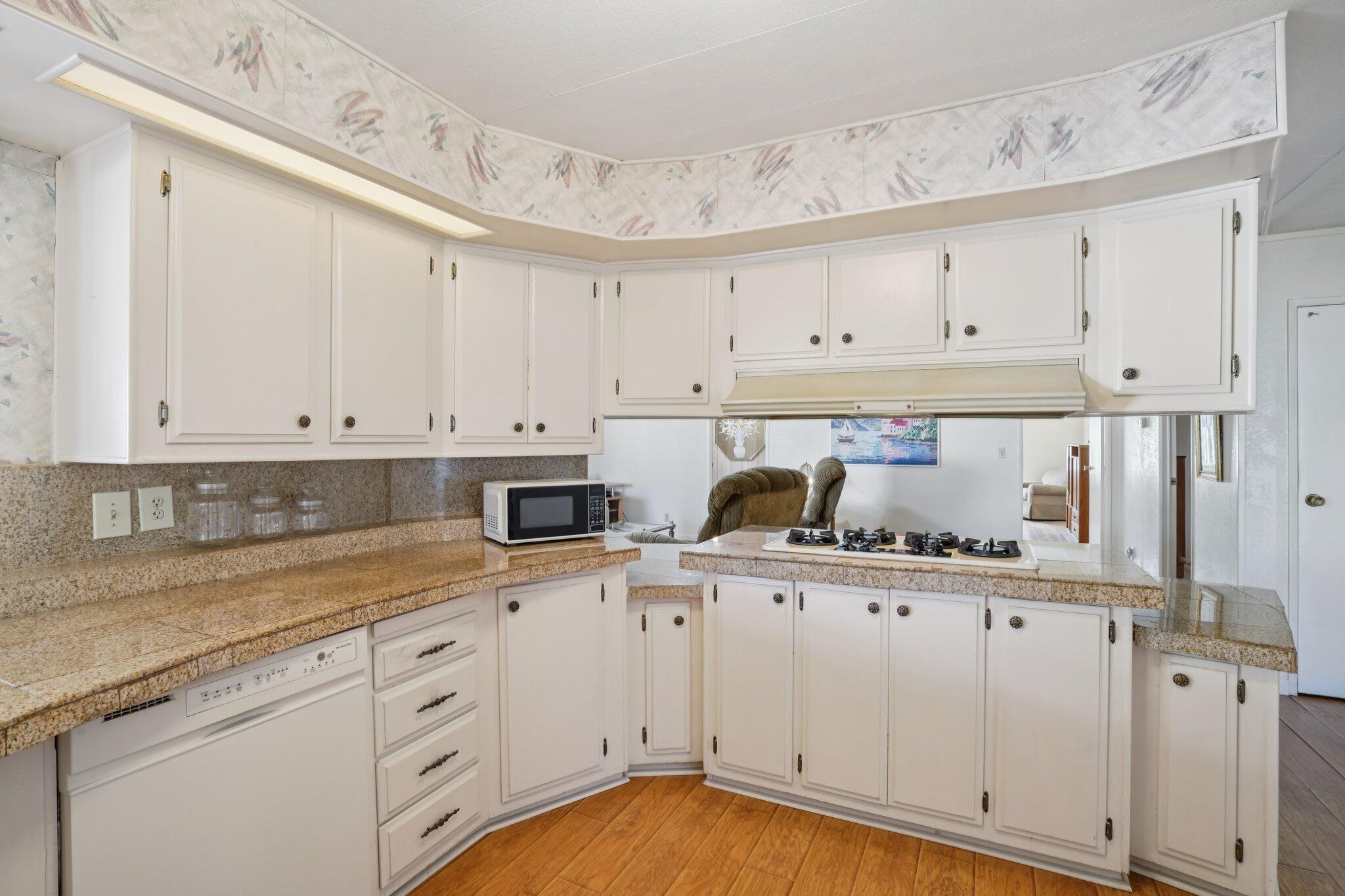 74584 Nevada Circle East Palm Desert, CA 92260 - Photo 18 of 46 a kitchen with granite countertop white cabinets and white appliances