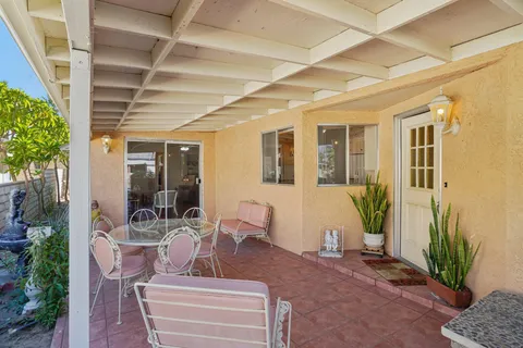a view of a patio with table and chairs and potted plants