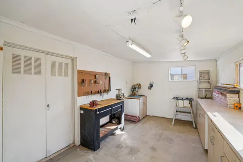 a view of a workspace with furniture and a window