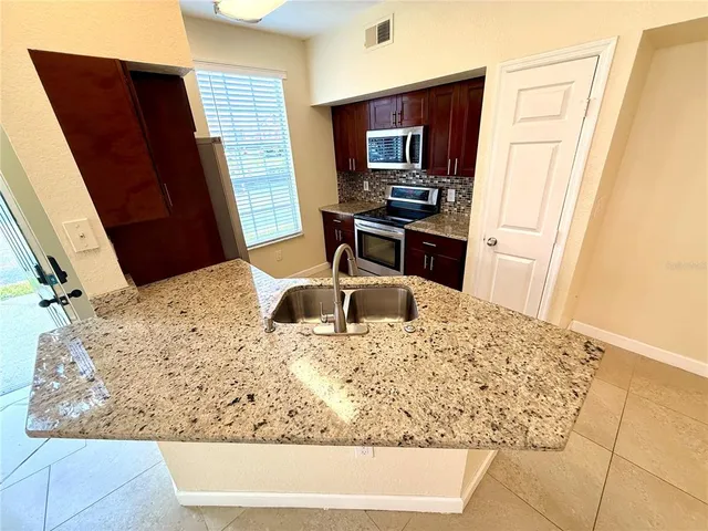 a kitchen with stainless steel appliances granite countertop a refrigerator and a sink