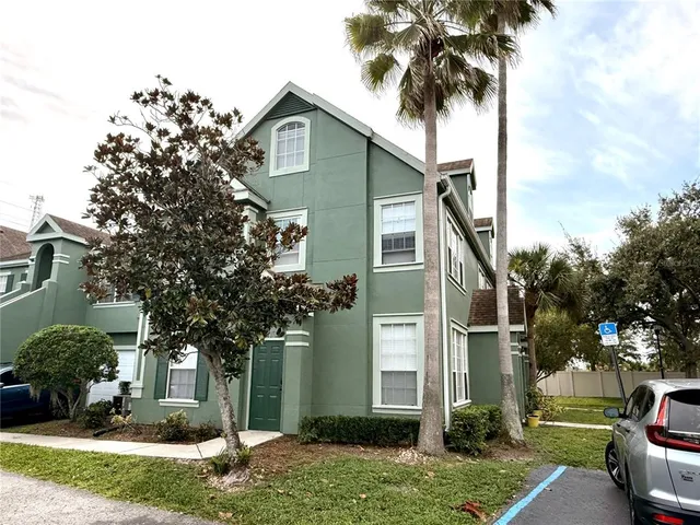 a front view of a house with a garden and trees