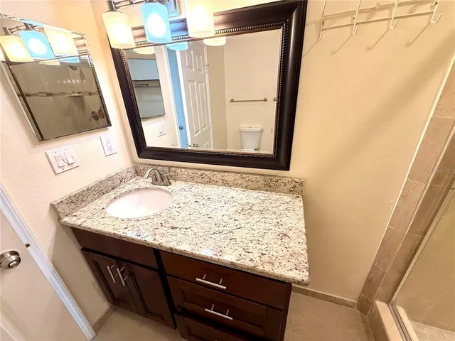 a bathroom with a granite countertop sink and a mirror