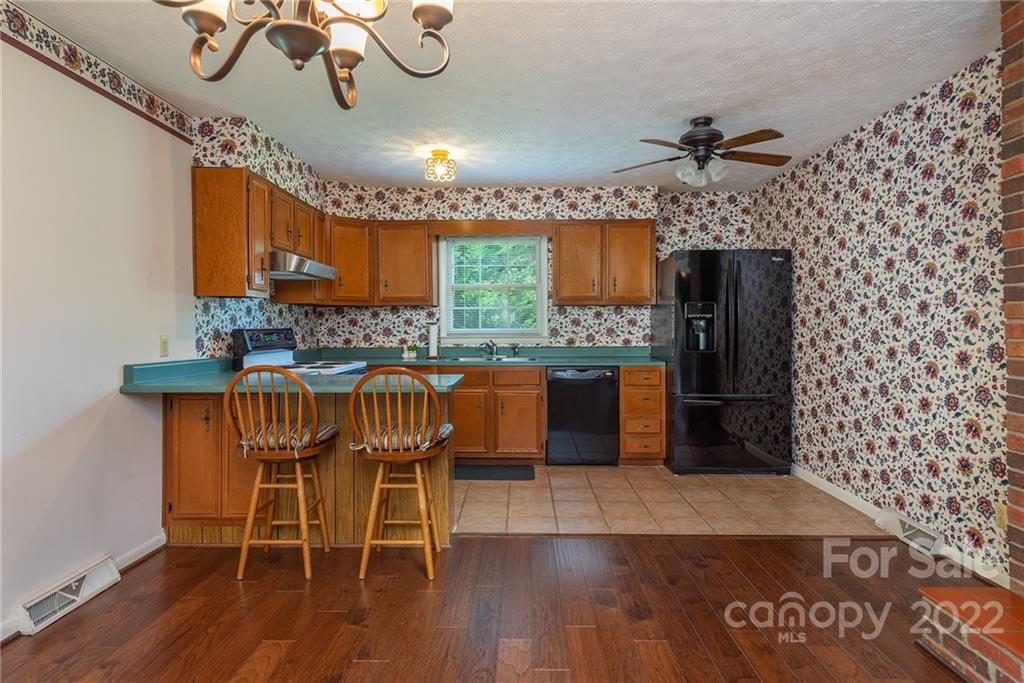62 Round Top Road Asheville, NC 28803 - Photo 10 of 46 a kitchen with granite countertop a stove a sink and a wooden table