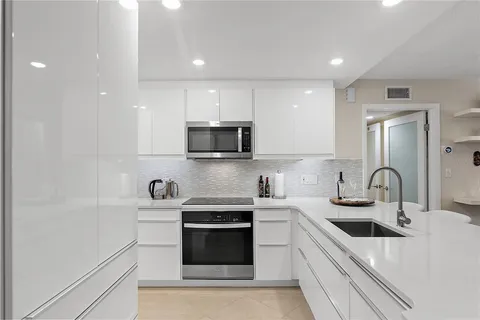 a kitchen with a sink a stove and cabinets