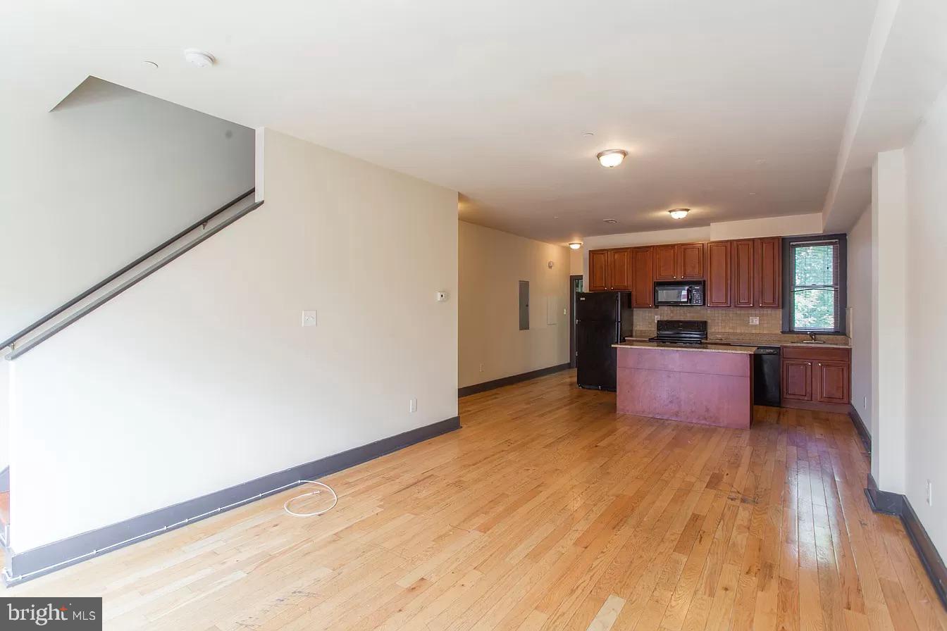 a view of kitchen with kitchen island and stainless steel appliances