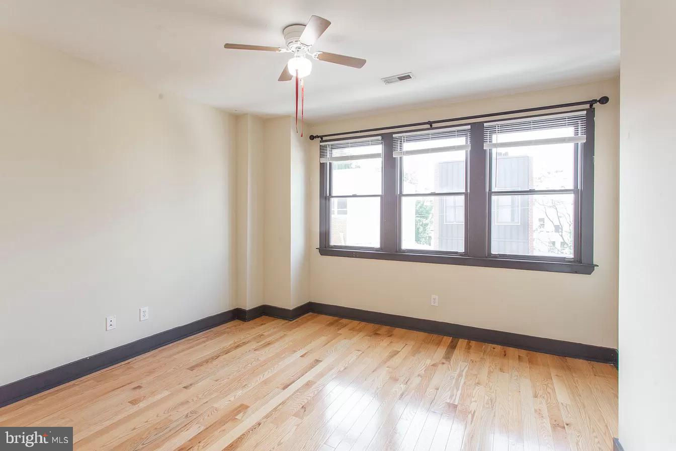 1826 West Norris Street, Unit 2 Philadelphia, PA 19121 - Photo 20 of 23 a view of an empty room with wooden floor and a window