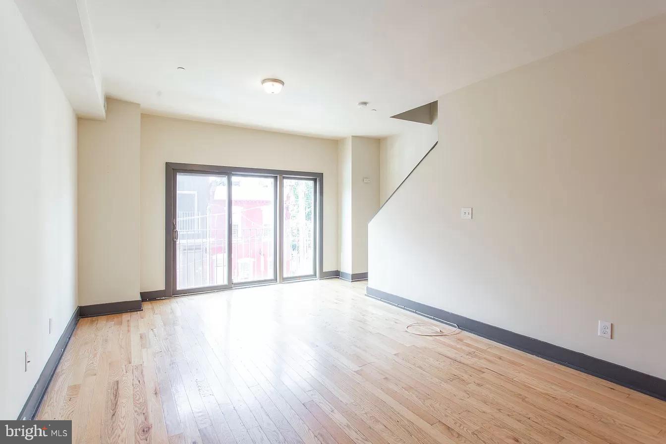 1826 West Norris Street, Unit 2 Philadelphia, PA 19121 - Photo 2 of 23 a view of an empty room with wooden floor and a window