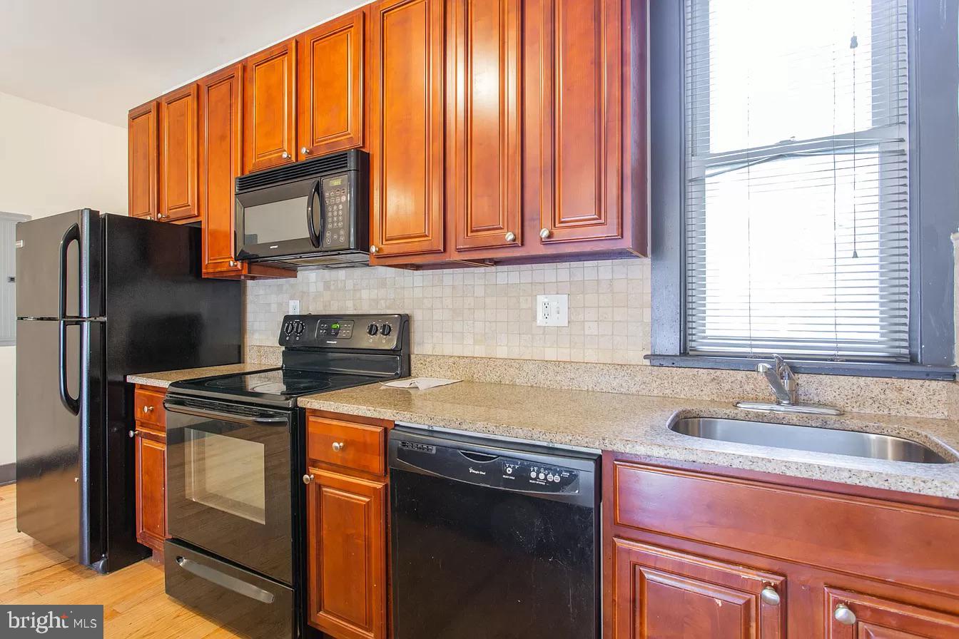 1826 West Norris Street, Unit 2 Philadelphia, PA 19121 - Photo 6 of 23 a kitchen with stainless steel appliances granite countertop a refrigerator stove and sink