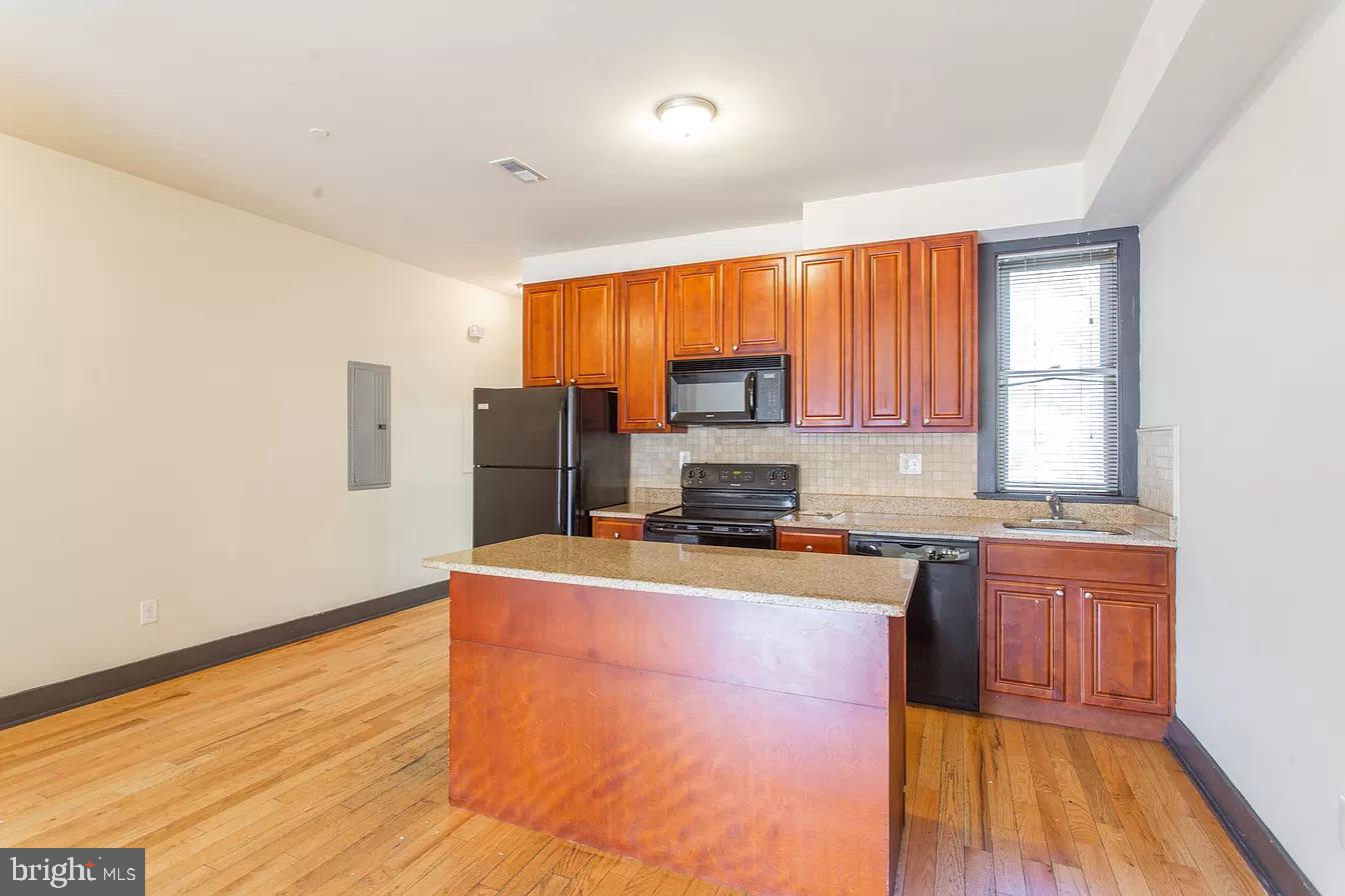 1826 West Norris Street, Unit 2 Philadelphia, PA 19121 - Photo 8 of 23 a kitchen with stainless steel appliances granite countertop a stove a sink a refrigerator white cabinets and wooden floor