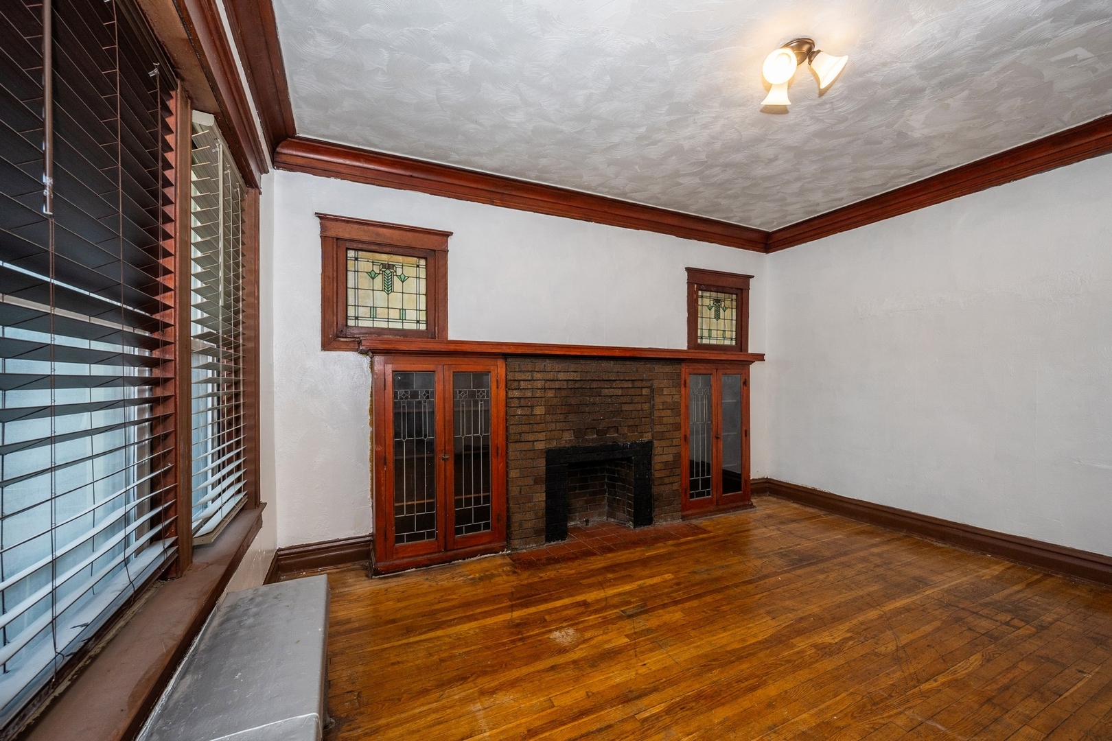 7348 South Indiana Avenue Chicago, IL 60619 - Photo 2 of 11 a view of an empty room with wooden floor fireplace and a window