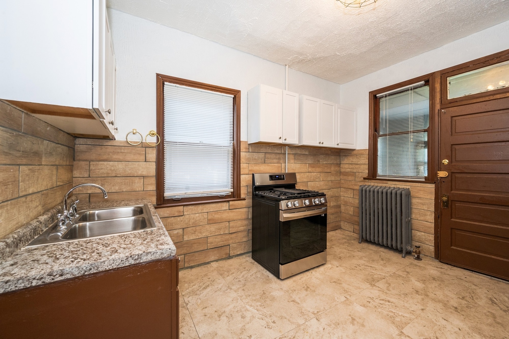 7348 South Indiana Avenue Chicago, IL 60619 - Photo 3 of 11 a kitchen with stainless steel appliances granite countertop a sink stove and refrigerator