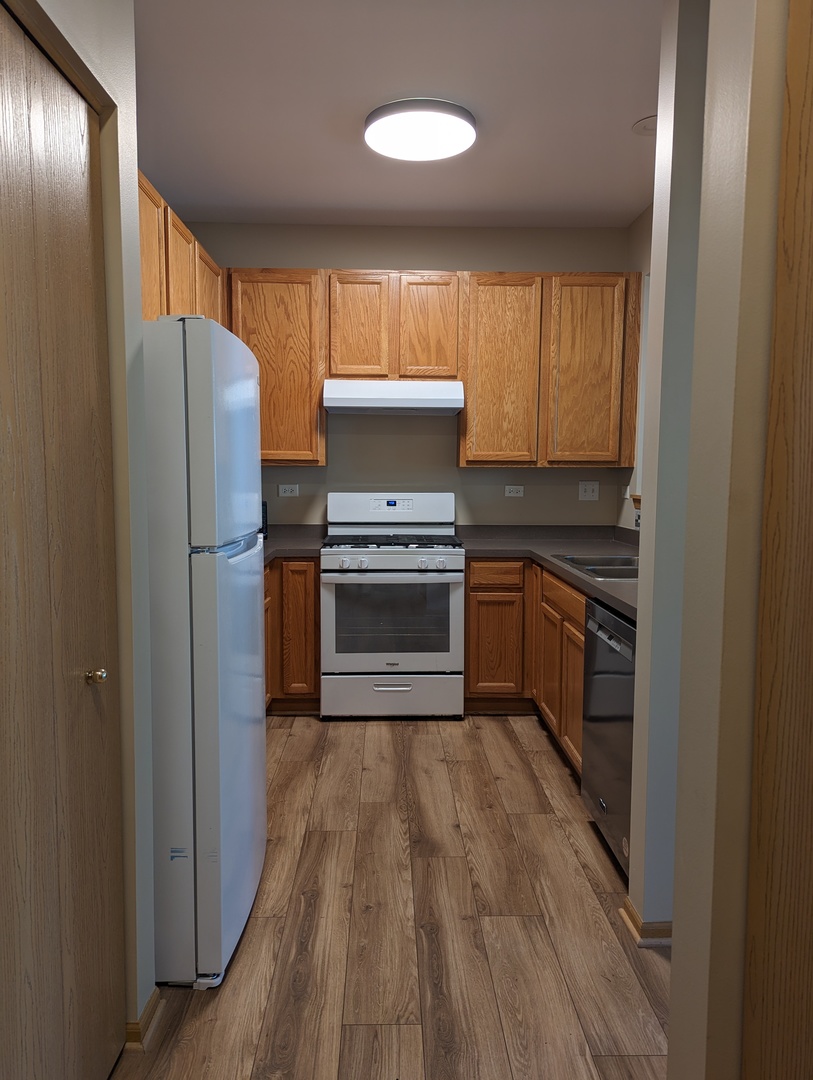 2257 Georgetown Circle Aurora, IL 60503 - Photo 6 of 19 a kitchen with wooden floors and stainless steel appliances