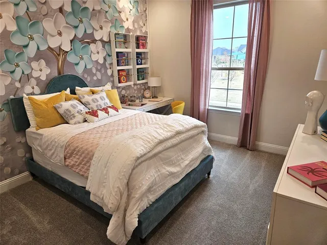 a bed sitting in a bedroom next to a window