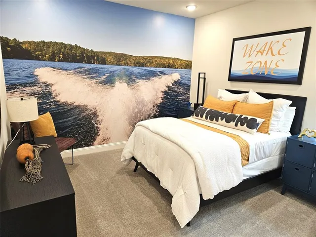 a bed sitting in a bedroom next to a lamp