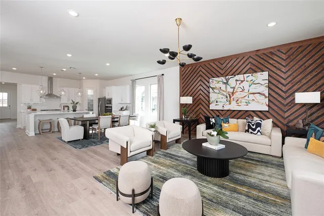 a living room with kitchen island furniture and a chandelier