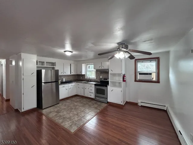 a view of kitchen with refrigerator microwave and wooden floor