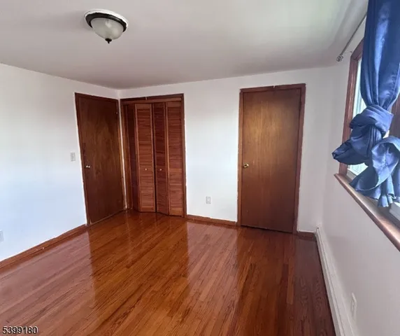 an empty room with wooden floor and closet