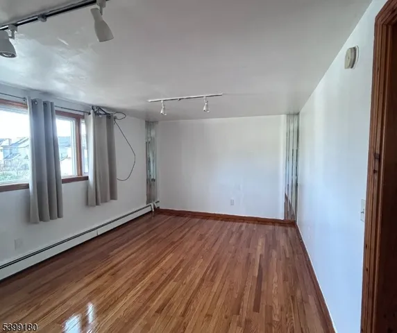 a view of a room with wooden floor and windows