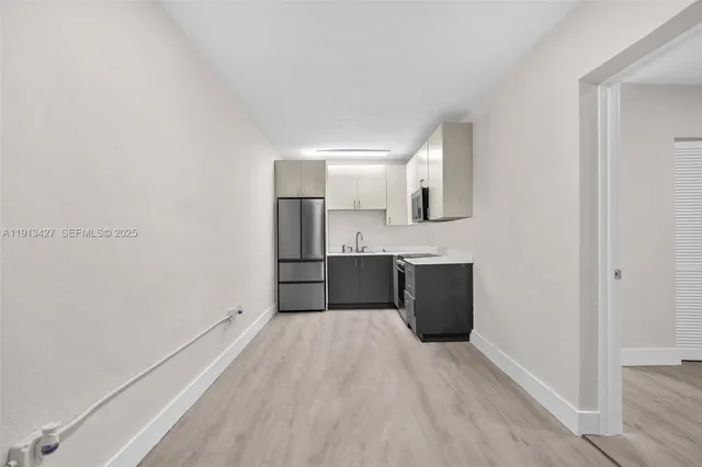 a kitchen with a refrigerator sink and cabinets