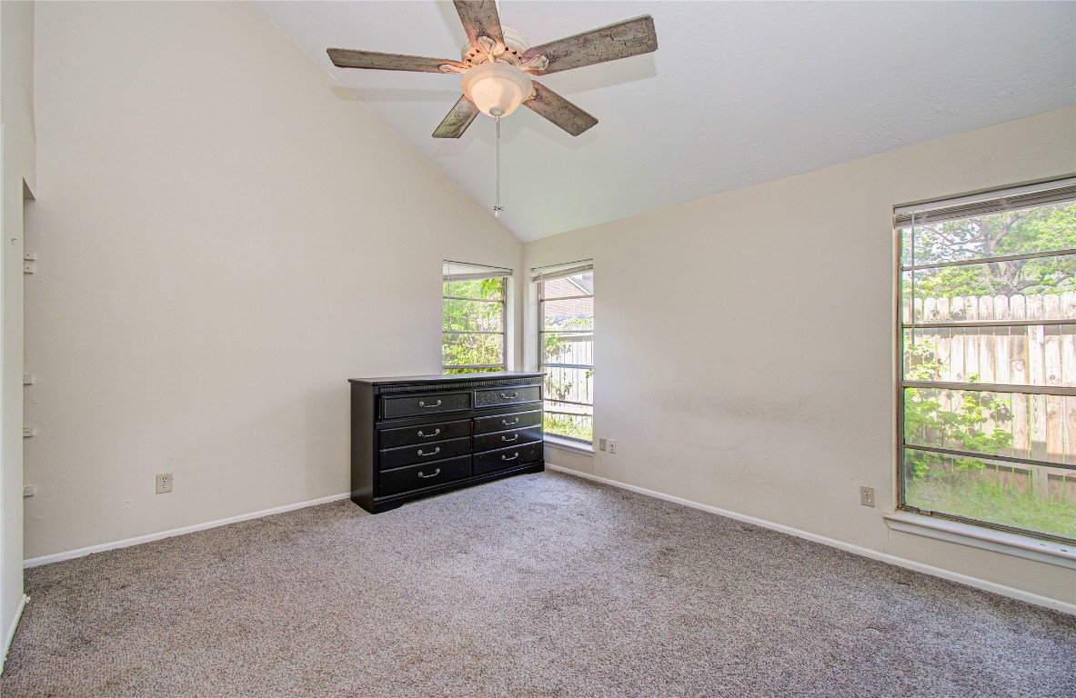 4911 Tealgate Drive Spring, TX 77373 - Photo 22 of 41 This room features a vaulted ceiling with a ceiling fan, carpeted floor, neutral walls, and large windows providing ample natural light.