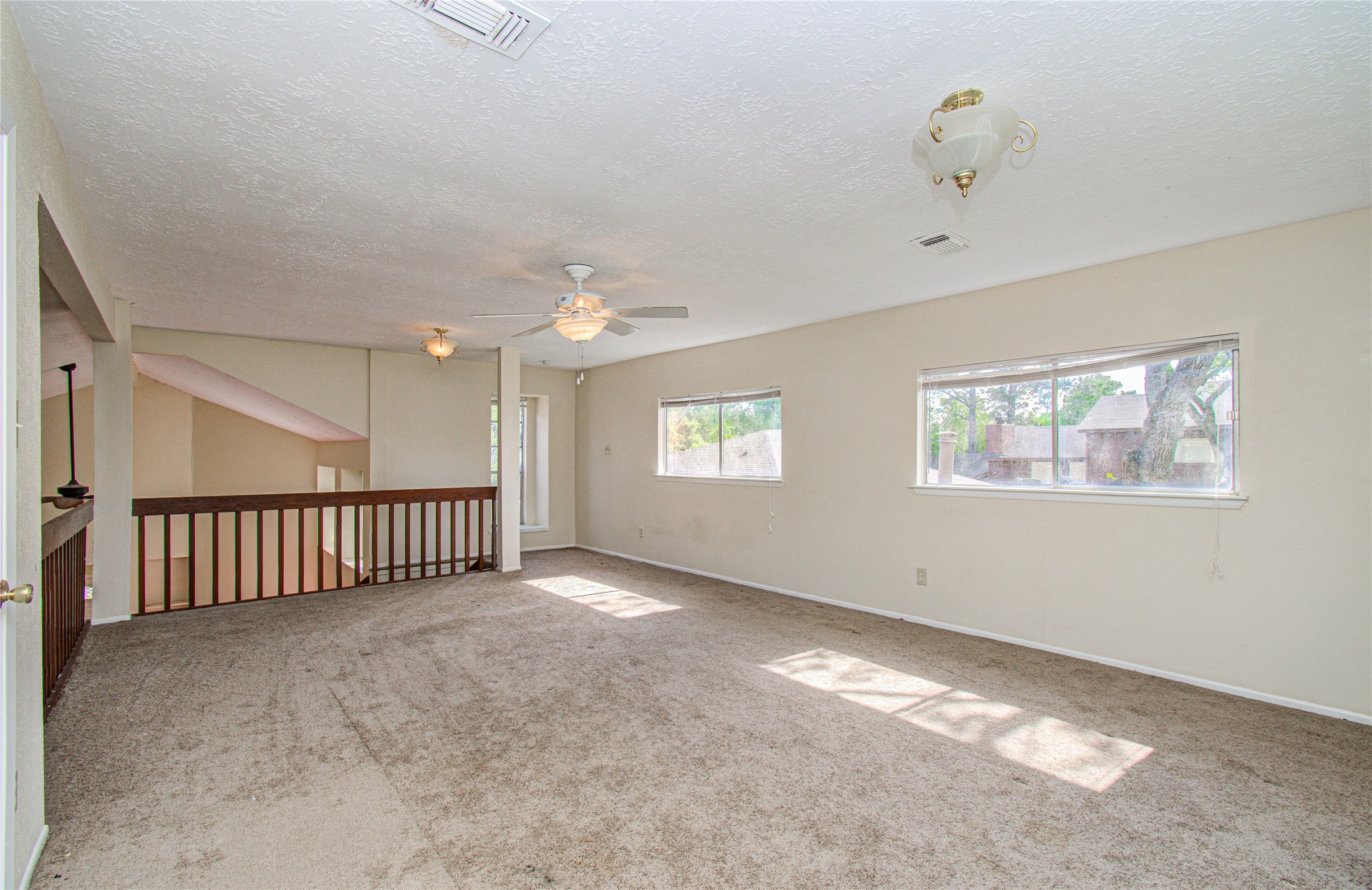 4911 Tealgate Drive Spring, TX 77373 - Photo 34 of 41 This spacious room features neutral walls, carpet flooring, large windows for natural light, ceiling fans, and a view of the neighborhood. Ideal for a family room or additional living space.