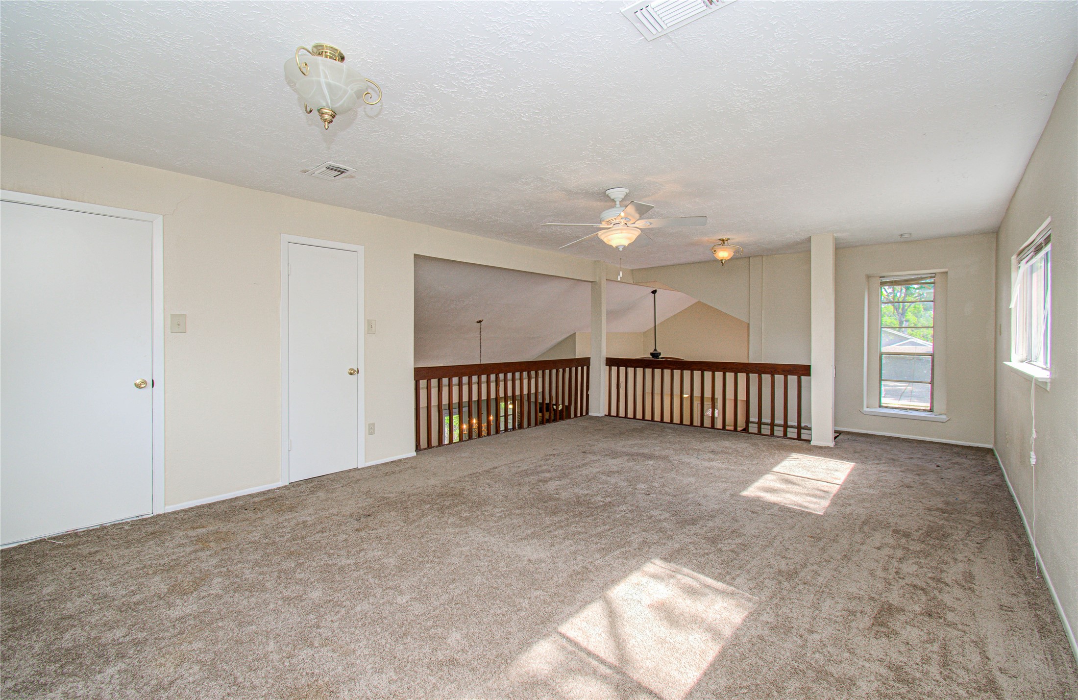 4911 Tealgate Drive Spring, TX 77373 - Photo 35 of 41 Spacious, carpeted loft area with natural light, ceiling fans, and railing overlooking the lower level, ideal for a family room or office.