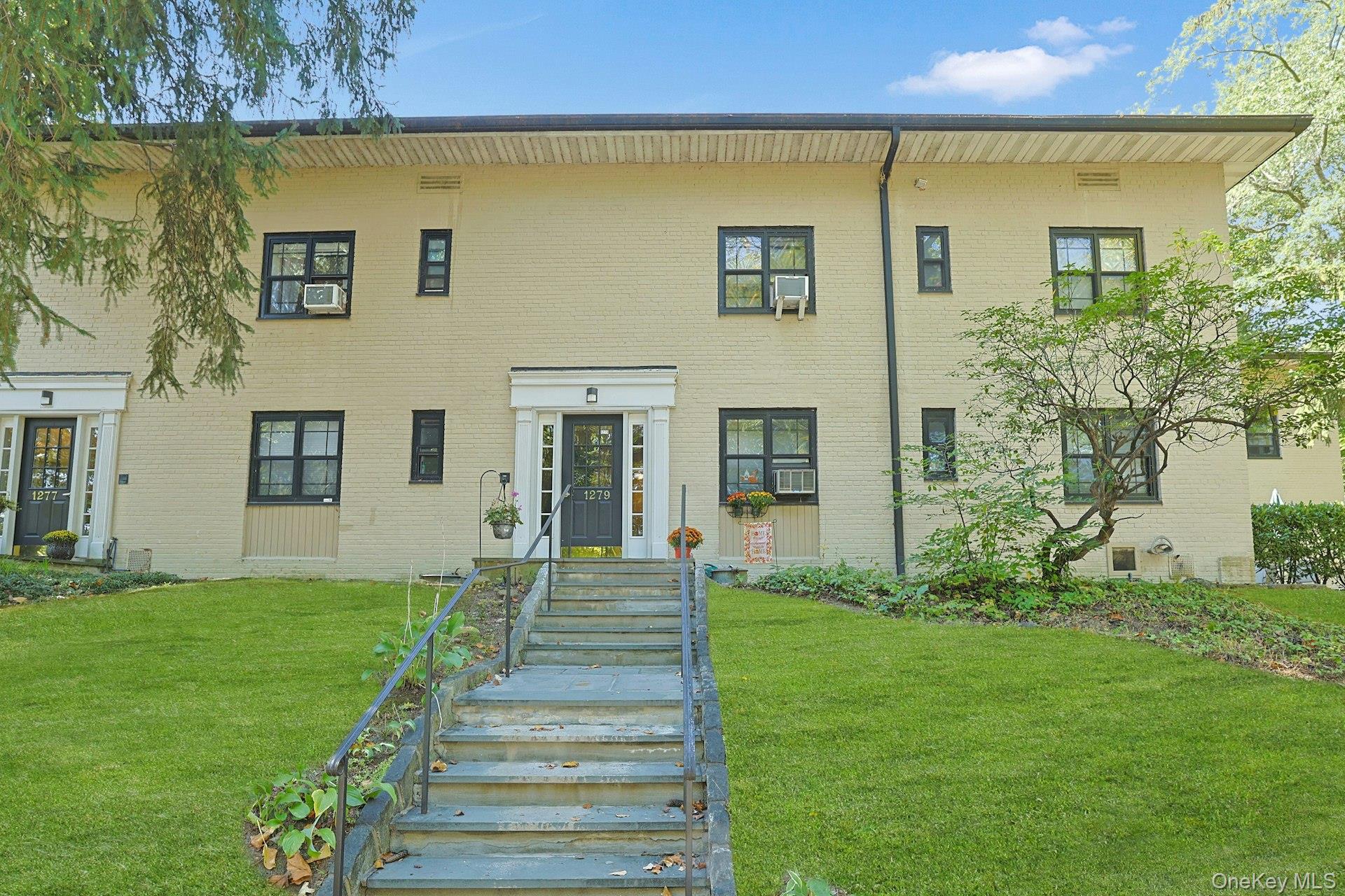 Colonial house with brick siding and a front lawn